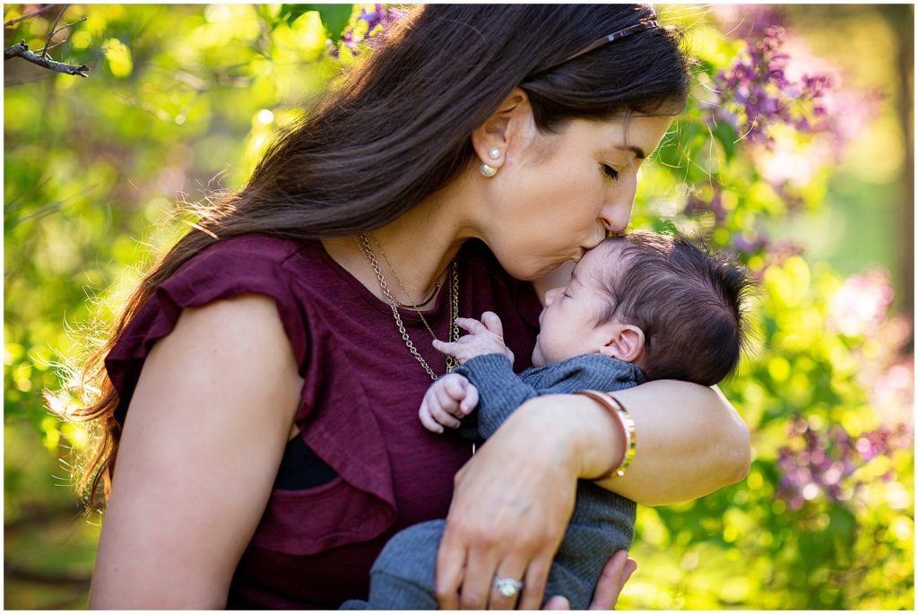 Woman kissing baby's head, featured in "What Time of Year is Best for my Family Session" blog post.