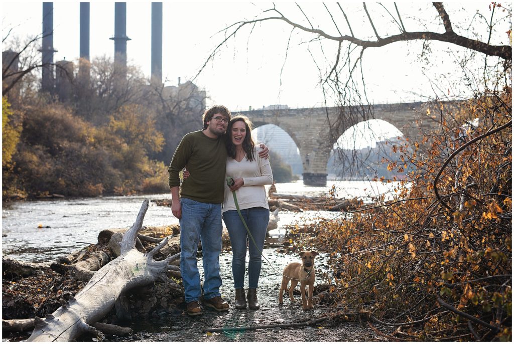 Couple with puppy with Stone Arch Bridge behind them