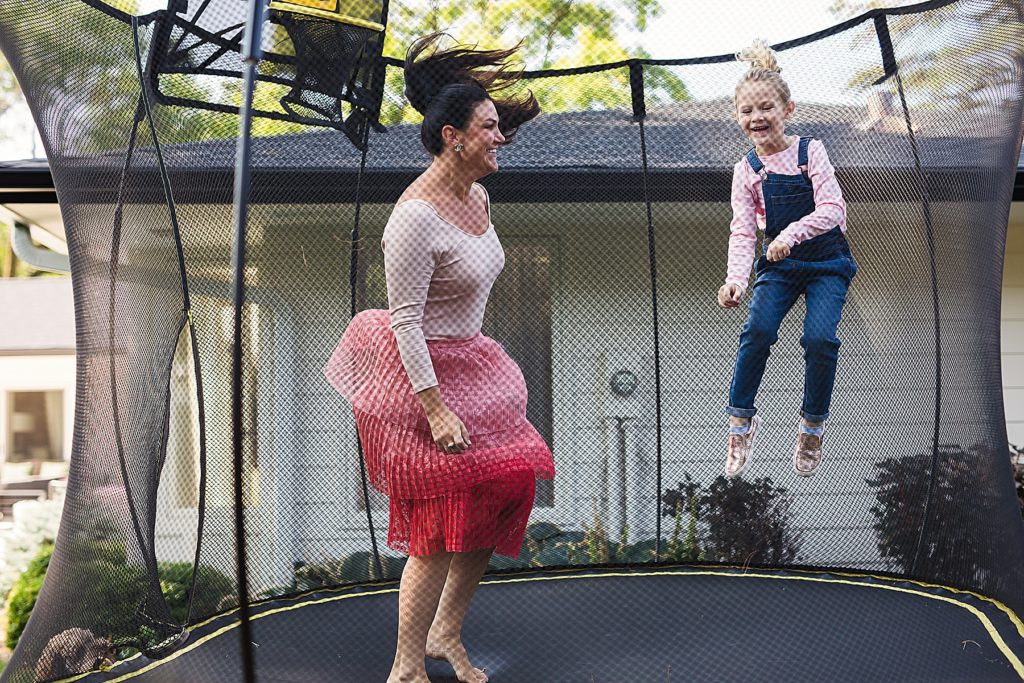 Mom and daughter jumping on trampoline