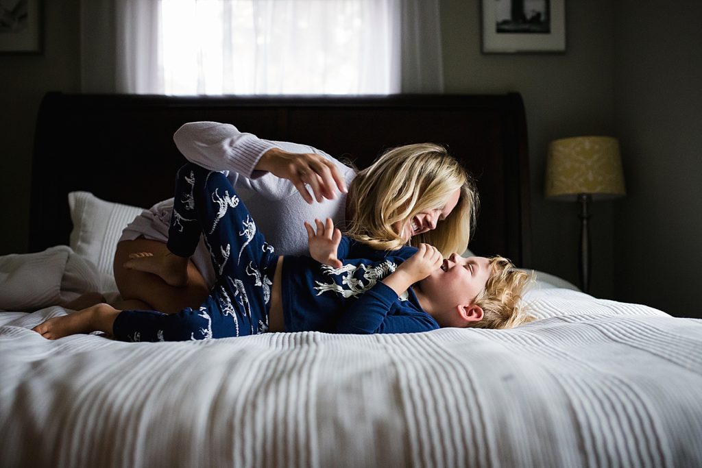 Mom and son laughing on bed