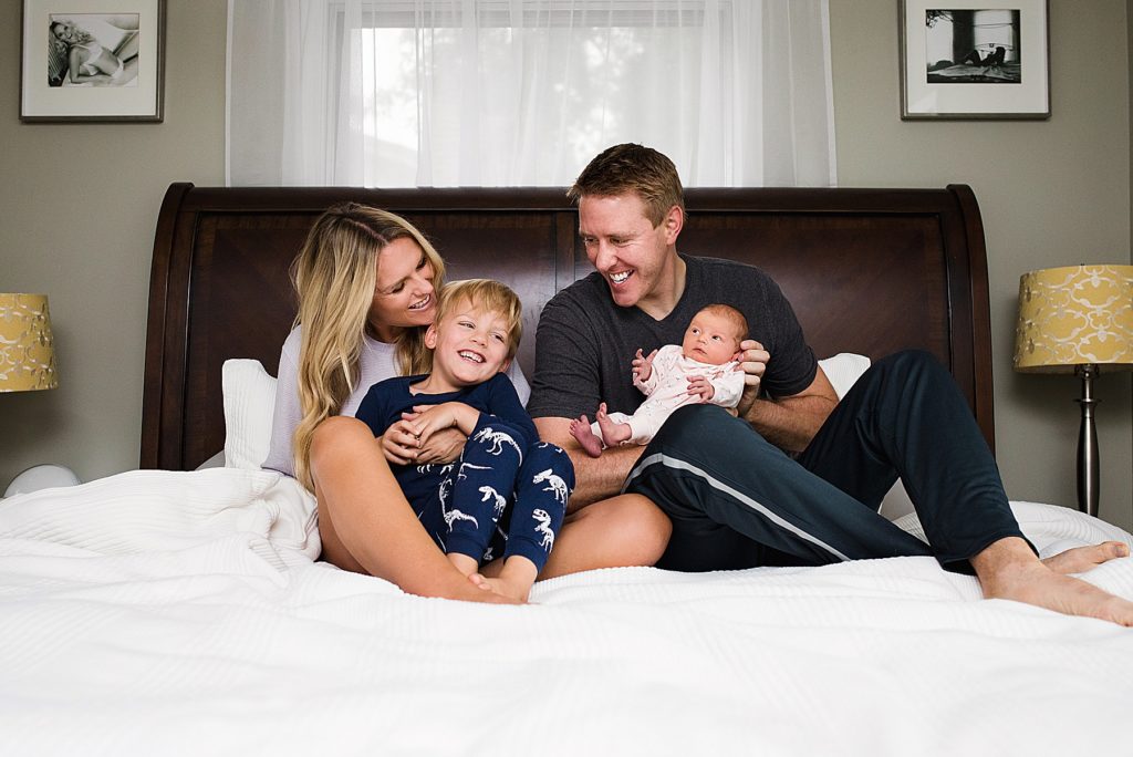 Family in pajamas holding newborn baby