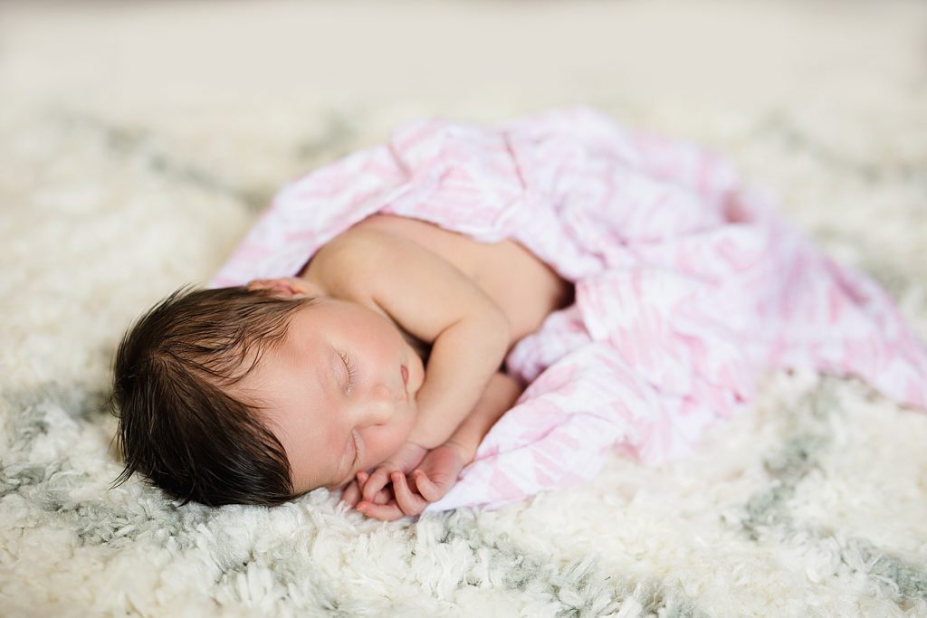 Newborn baby laying in pink blanket