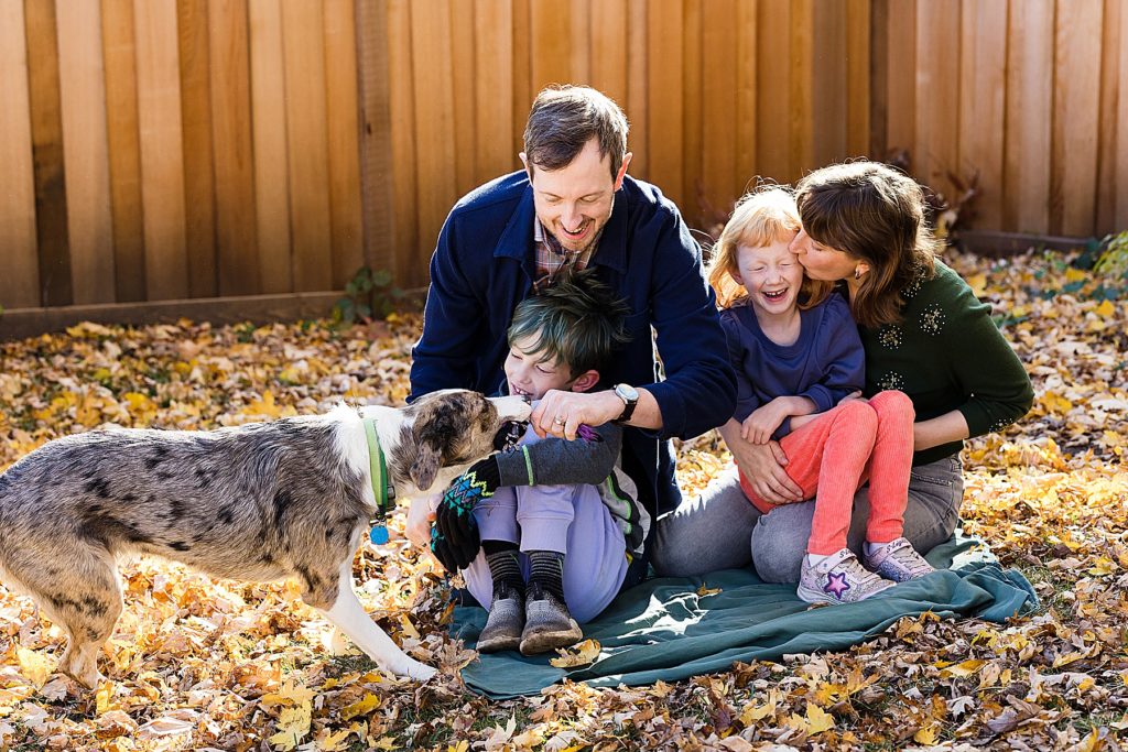 Minnesota Family Photographer captures dad, mom and two kids playing with dog.