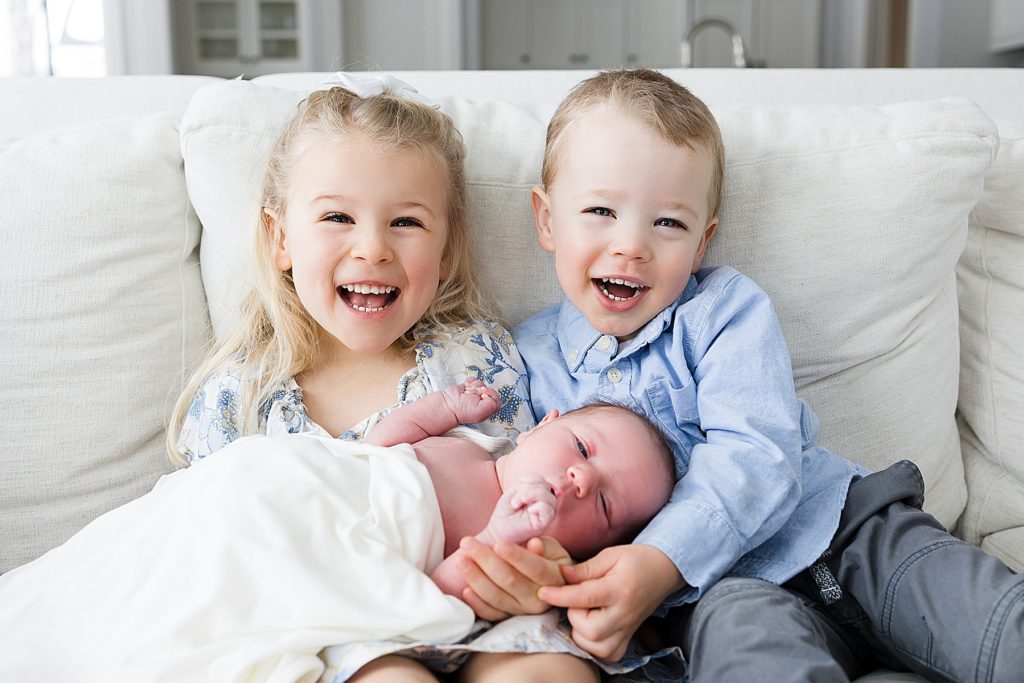 Big Sister and Big Brother smiling with new baby
