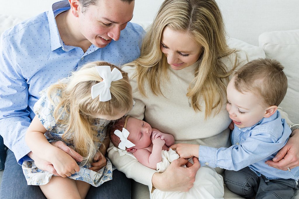 Minneapolis newborn photos with the entire family looking at baby