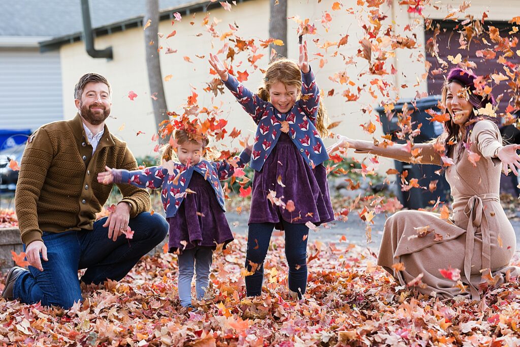 Family throwing leaves in the air in the fall. St. Paul, MN
