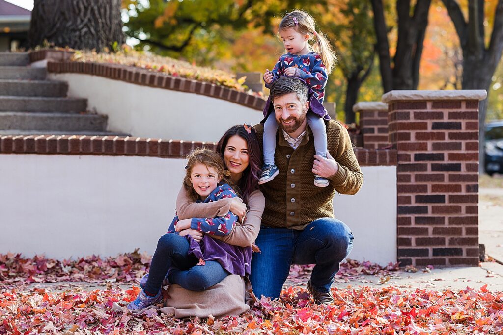 Family of four in St. Paul, MN sitting in the fall leaves