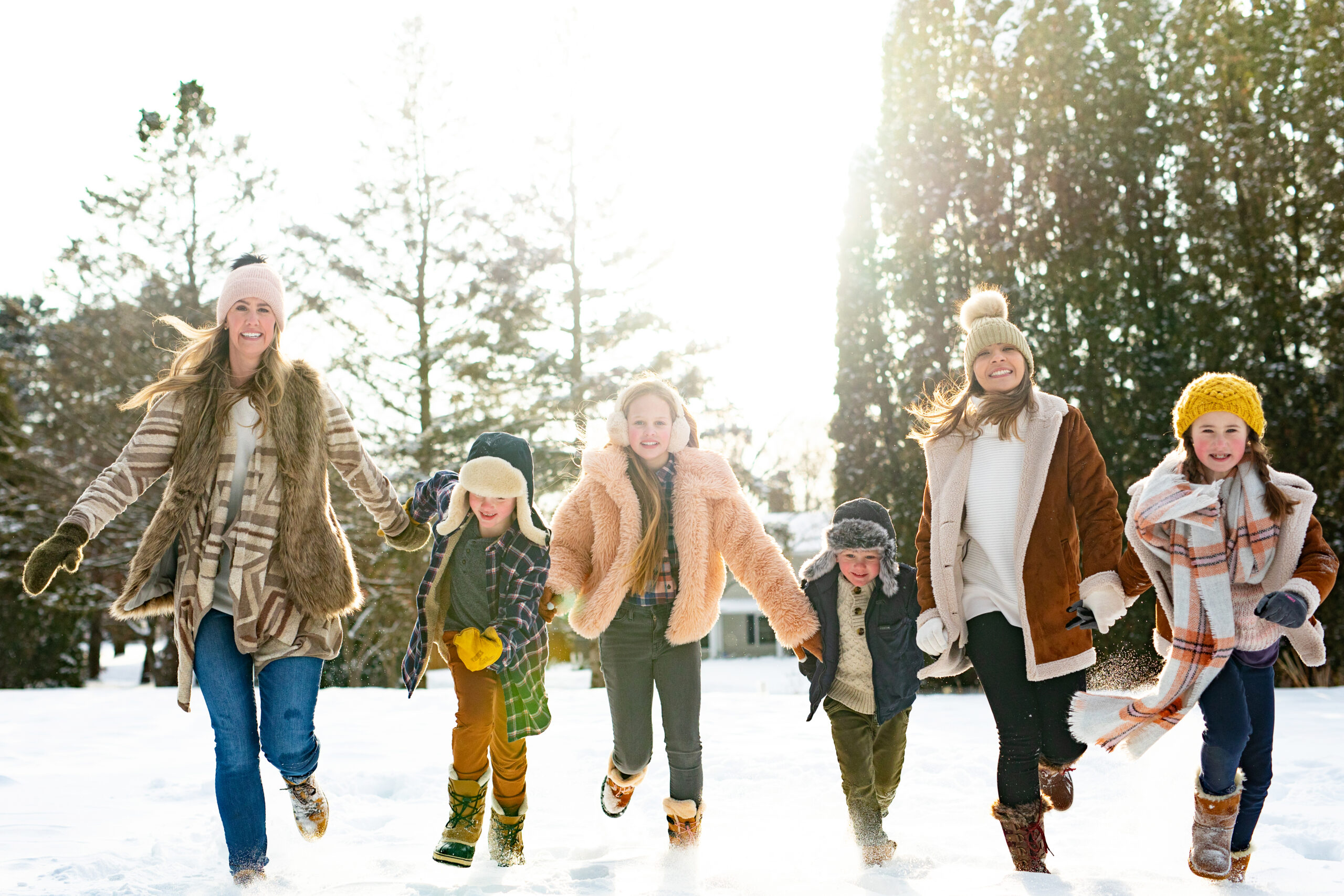 Family running in the snow at Arneson Acres in Edina, MN for family photography