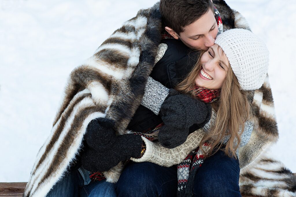 Winter engagement with a couple snuggling in a blanket in Eden Prairie, MN