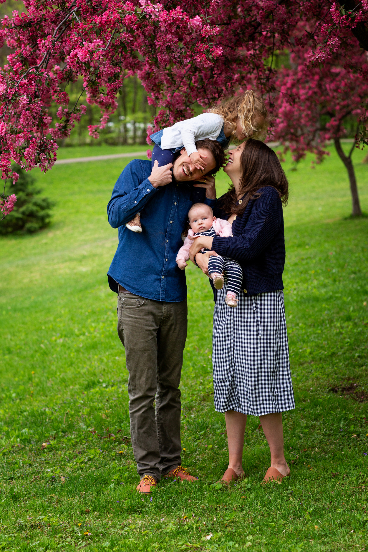 A playful moment under blooming trees—spring family photos full of connection, color, and joy.