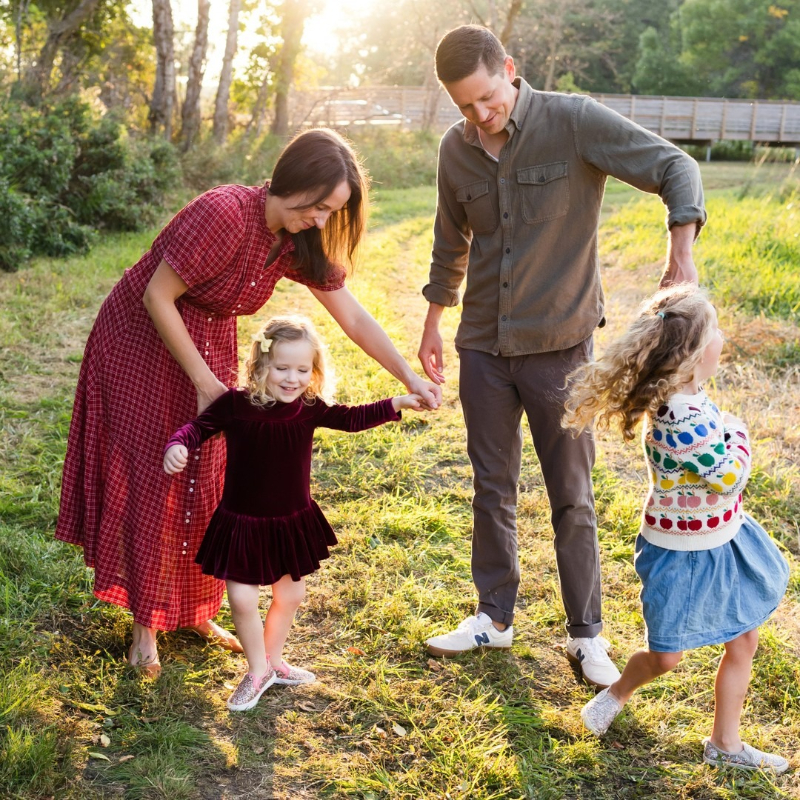 Family dancing in golden sunlight during a joyful session, one of many meaningful things to do with your photos.
