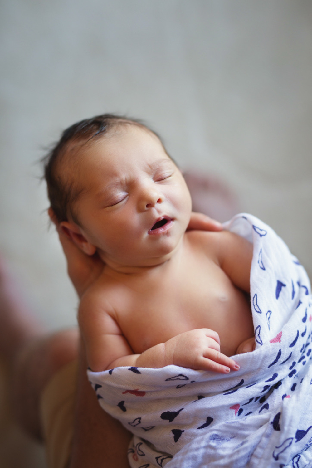 A newborn baby swaddled and yawning, the kind of postpartum season therapy for women can help Minnesota moms navigate 